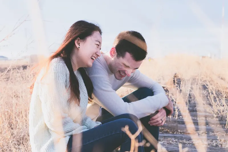 Happy couple laughing together on a first date — shared laughter predicts connection